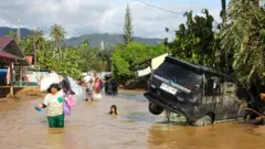 Warga melintas di area banjir bandang dan longsor di Kelurahan Huta Nabolon, Kecamatan Tukka, Kabupaten Tapanuli Tengah, Sumatera Utara, Rabu (3/12/2025).