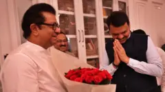 राज ठाकरे आणि देवेंद्र फडणवीस भेटी दरम्यान हस्तांदोलन करताना.