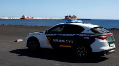 Un coche de la Guardia Civil en el puerto que espera al buque.