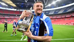 Jamie Vardy smiles as he lifts the FA Cup in 2021