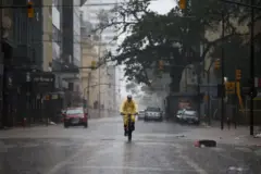 Pessoa andando de bicicleta em meio à chuva