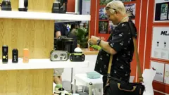 Visitante da Feira de Cantão examina produtos em um estande