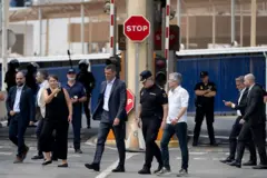 O primeiro-ministro espanhol, Pedro Sánchez, e seu ministro do Interior, Fernando Grande Marlaska, caminham perto da muralha da fronteira de Tarajal, que separa o enclave espanhol de Ceuta, no norte da África