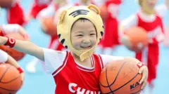 Menino pequeno segura uma bola de basquete