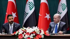رجب طیب اردوغان و علی زیدی در نشست رسمی در کنار هم نشسته‌اند، پشت سر آنها پرچم‌های دو کشور و جلوی آنها یک دسته گل بزرگ