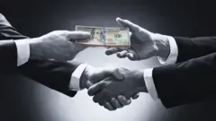 ገንዘብ የሚቀባበሉ እጆች 