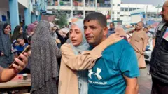 Palestinians react after a reported Israeli air strike in Jabalia