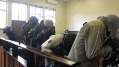 The five suspects flesh-eating case cover their faces during their appearance at the Estcourt Magistrates Court on August 28, 2017 in Estcourt, South Africa.