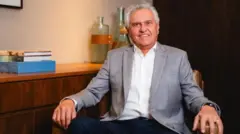 Caiado sentado em uma cadeira e sorrindo