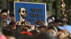 Seguidores del presidente de El Salvador, Nayib Bukele, sostienen un cartel en su apoyo durante un mensaje a la nación por su sexto año al frente del gobierno afuera del Teatro Nacional, en el centro histórico de San Salvador, el 1 de junio de 2025.