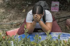 Una mujer está sobre sus rodillas, hincada rezando
