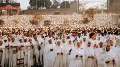 ነጭ ለብሰው የሚነድ ጧፍ የያዙ ሴቶች