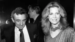 Louis Malle y Candice Bergen en atuendos elegantes (en escala de grises)