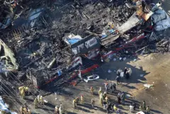 Cena do incêndio na boate Station, vista de cima. O prédio aparece completamente destruído pelo fogo, com pouco restando após as chamas serem extintas.
