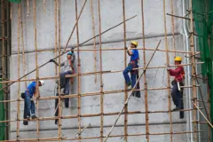 Operários em andaimes de bambu