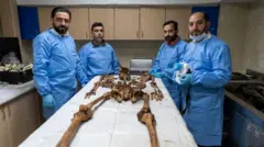 مسعفون يقفون إلى جوار رفات بشرية