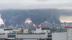 Densas colunas de fumaça, acompanhadas por chamas, se elevam de uma refinaria de petróleo em Moscou
