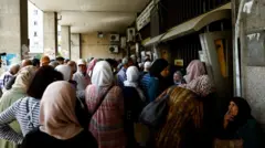 Pessoas se reúnem do lado de fora de um banco depois de Trump anunciar o fim das sanções à Síria