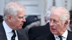 Prince Andrew and the King dressed in black suits leave a funeral at Westminster Cathedral