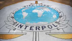 Mosaico no piso do edifício da Interpol mostrando o logo da organização
