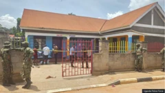 Àwọn ológun dúró sí iwájú ilé ẹ̀kọ́ tí wọ́n ta okùn síwájú rẹ̀, àwọn èèyàn kan wà nínú ọgbà ilé ẹ̀kọ́ náà.