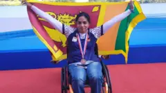 ක්‍රීඩා ජයග්‍රහණයකින් පසු සිංහ කොඩිය ඉදිරිපස රෝද පුටුවක වෛද්‍ය සමිතා සමන්මලී සිටී.