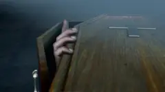 Mão de pessoa dentro de caixão tentando abrir a tampa do mesmo