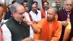 योगी आदित्यनाथ मिठाई खिलाते हुए