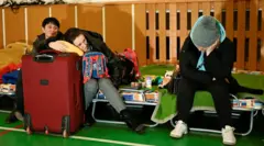 أشخاص يستريحون في ملجأ للاجئين في سلوفاكيا مع حقائب سفر
