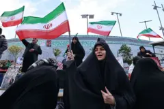 Mujeres iraníes ondean banderas nacionales mientras la gente se reúne en la Plaza de la Revolución de Teherán después de que Estados Unidos e Irán acordaran un alto el fuego de dos semanas.