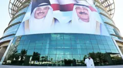 Ciudadanos kuwaitíes pasan frente a grandes retratos del emir de Kuwait, el jeque Mishal al Áhmad al Yáber al Sabah, y del príncipe heredero, el jeque Sabah al Jalid al Sabah, exhibidos en la fachada del Instituto de Diabetes Dasman en Ciudad de Kuwait el 10 de marzo de 2026.