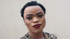 Hoton Bobrisky ya shafa fankeke da kwalli a ido, da garin gashin ido, ya kuma yi shanfo a kai da rangada jan baki.
