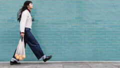 امرأة تسير إلى جانب جدار