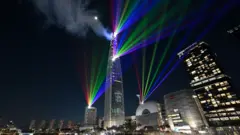 Luces láser iluminan el cielo nocturno sobre la Torre Lotte World, el edificio más alto de Corea del Sur, en Seúl.