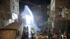 عناصر دفاع مدني تعمل في منطقة بعدما وصف بأنه ضربة أمريكية استهدفت حي فروة في صنعاء