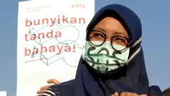 seorang perempuan melakukan aksi unjuk rasa tentang kekerasan seksual