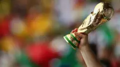 Mano sosteniendo una copa del Mundo de imitación en un estadio lleno.