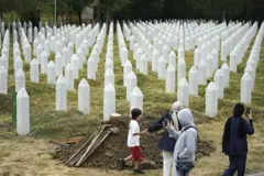 Cuatro personas recorren el memorial que recuerda en Potocari a las víctimas de Srebrenica.