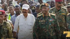 ብሓለውቲ ዝተዓጀቡ ካኪን ቆቢዕን ዝተኸደነ ፕረዚደንት ኢሳይያስ ኣፈወርቂን፡ ምሉእ ወተሃደራዊ መዓርጉ ዝለበሰ ጀነራል ዓብደልፋታሕ ኣልቡርሃንን፡ ህዝብን መካይንን ደድሕሪኦም እናሰዓቡ