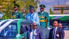 Onyeisiala Tinubu mechara kwụrụ n'ụkwụ ya n'elu ụgbọala ahụ dịka ọ dachara