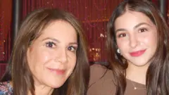 Mãe e filha sorriem para a foto