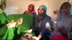 Awọn Dokita ati oṣiṣẹ ilera to di foonu mu lati fi rina ṣe iṣẹ abẹ