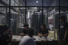 Supapong Pruenglampoo, the head brewer and co-founder of the United Peoples Brewery, with colleagues outside the United Peoples Brewery restaurant in Bangkok, Thailand, on Wednesday, July 26, 2023. Thailand's cabinet approved an additional public holiday on July 31 to set a six-day break for most workers in a bid to spur tourism and private consumption. Photographer: Chalinee Thirasupa/Bloomberg via Getty Images