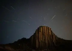 Kapan dan di mana publik Indonesia bisa menyaksikan hujan meteor Perseid? - BBC News Indonesia 1 Garis-garis metero terlihat di atas puncak tebing di Baochang, Mongolia Dalam, Tiongkok pada 13 Agustus 2021
