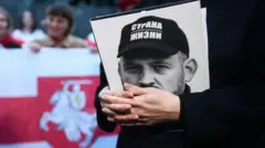 Світлана Тихановська тримає фото чоловіка Сергія Тихановського під час зустрічі з білорусами на головній площі Кракова, Польща, 2 жовтня 2022 року.