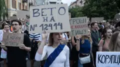 Protesters in Kyiv hold placards against corruption