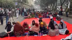 আজিজ সুপার মার্কেটের সামনে বিক্ষোভকারীদের কয়েকজনকে দেখা গেছে সকাল সাড়ে নয়টা নাগাদ