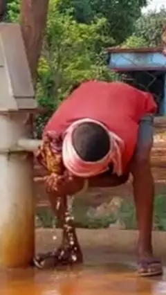 हैंडपंप से पानी पीता शख़्स