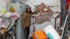 2025年1月21日台灣發生地震後，台南一名男子展示家中受損的牆壁。