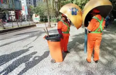 Dois garis usando o telefone público